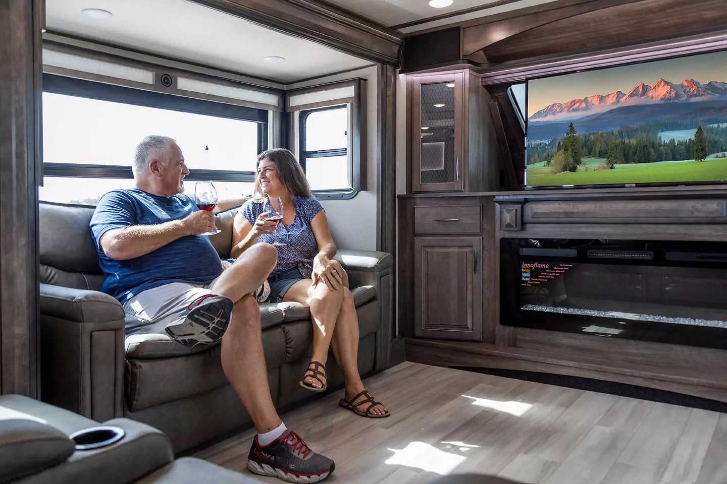 Couple sitting in RV, having a drink.