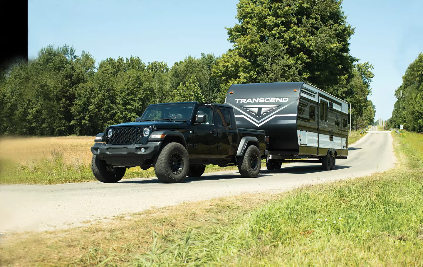 Transcend Xplor being towed by a Jeep in the country.