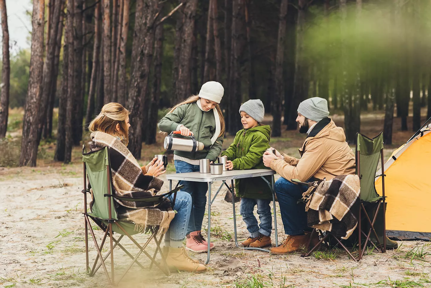Friends sitting around a table in camping chairs