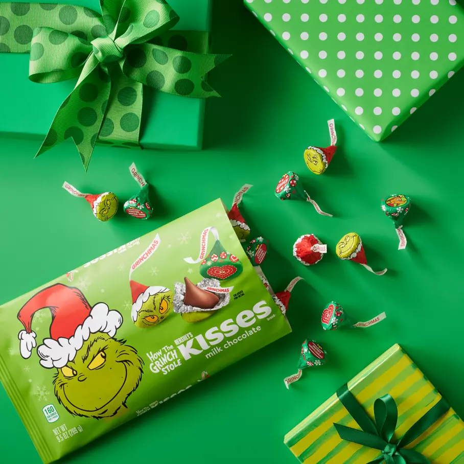 HERSHEY'S KISSES Grinch® Foil Candies beside gifts