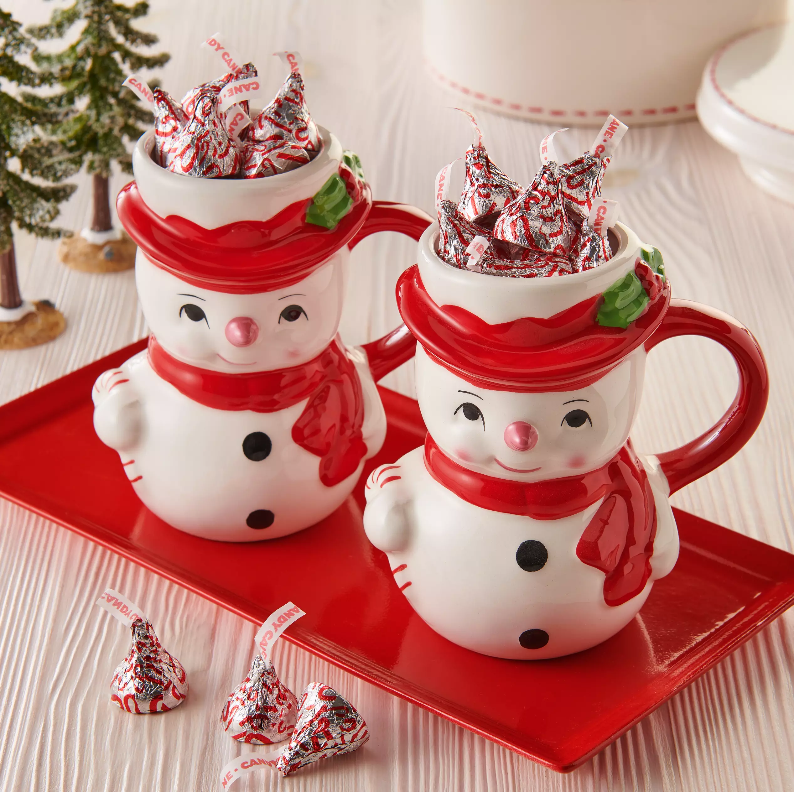 two snowman mugs filled with hersheys kisses candy cane mint candy