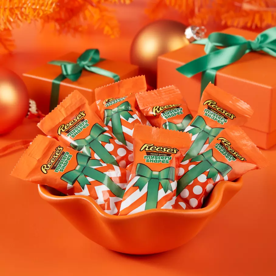 orange bowl filled with packs of reeses holiday snack size mystery shapes