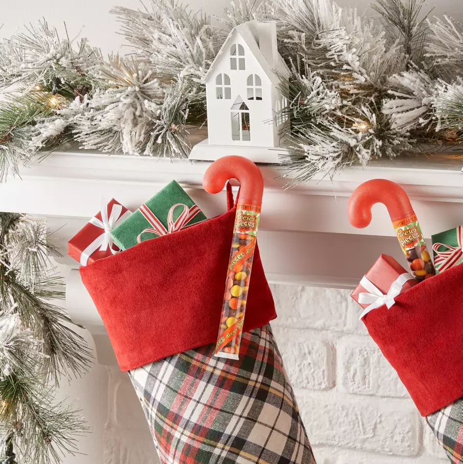 reeses pieces holiday peanut butter candy canes hanging from christmas stockings