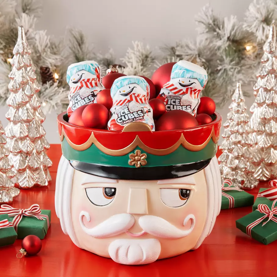nutcracker themed bowl filled with ornaments and bottles of ice breakers ice cubes snowman candy cane sugar free gum