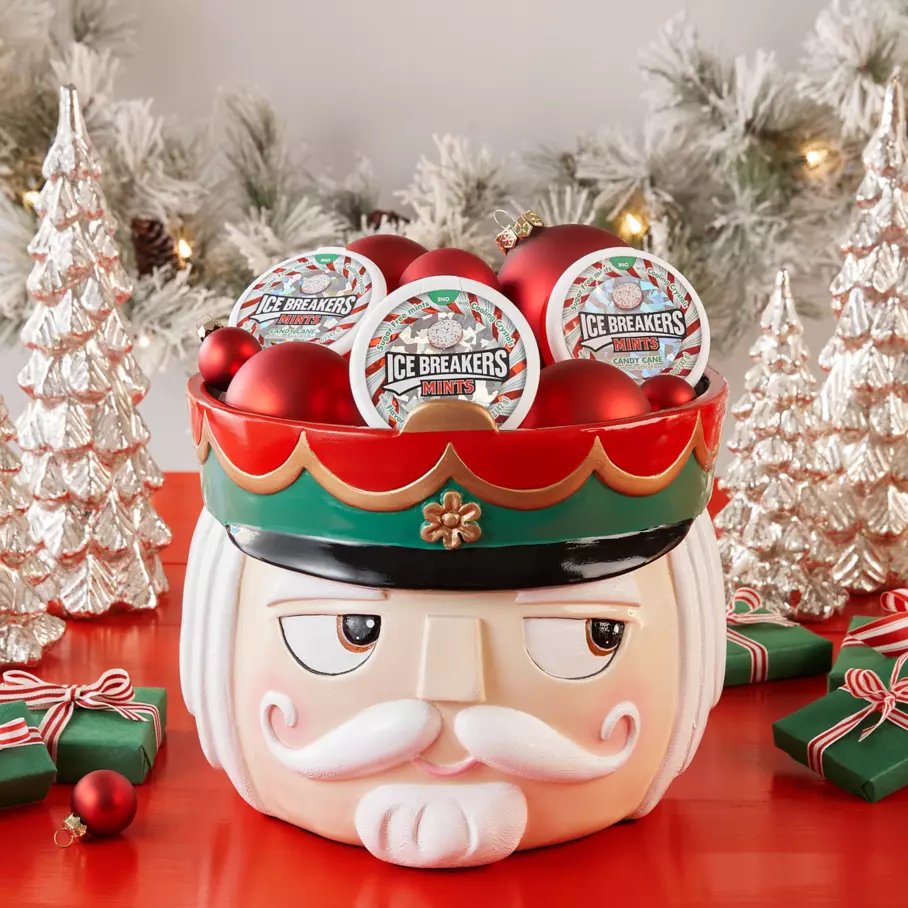 nutcracker themed bowl filled with ornaments and pucks of ice breakers candy cane sugar free mints