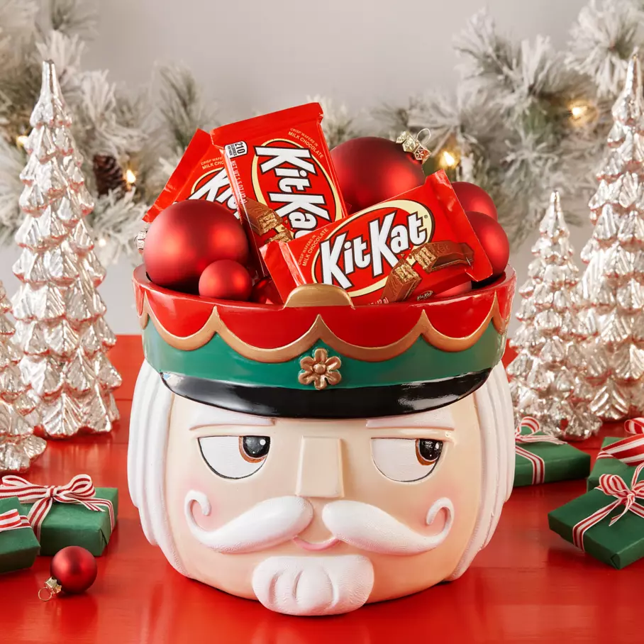 nutcracker themed bowl full of ornaments and kit kat milk chocolate candy bars