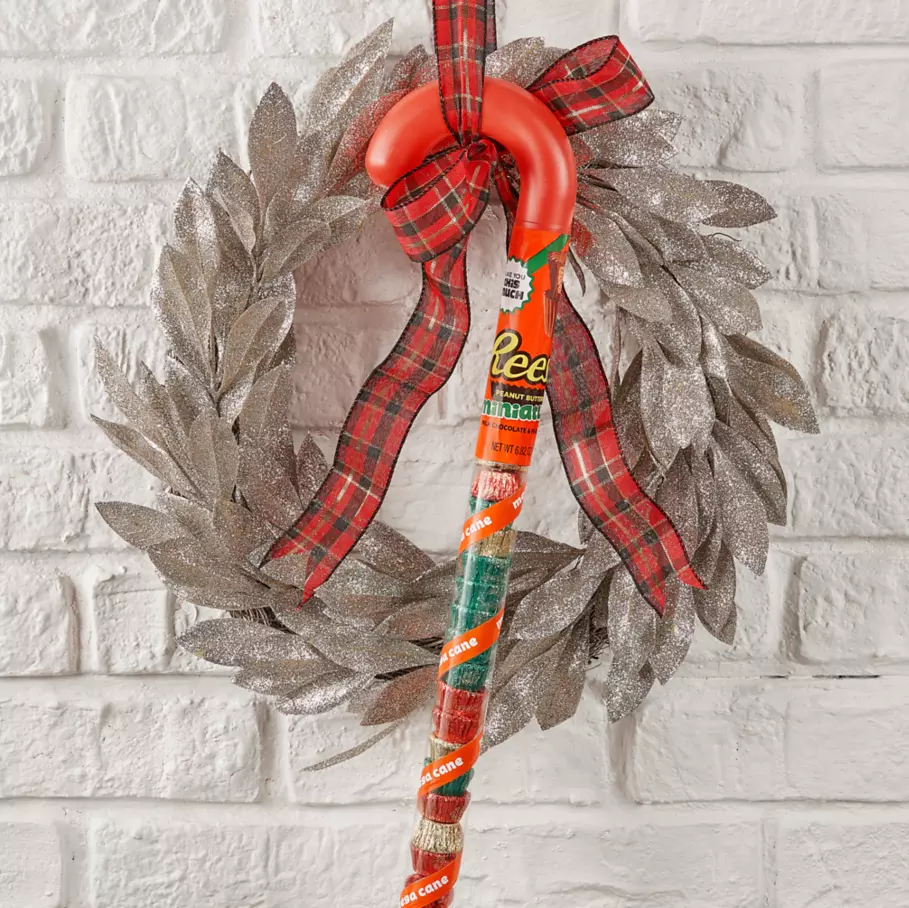REESE'S Holiday Candy Cane hanging from a Christmas wreath