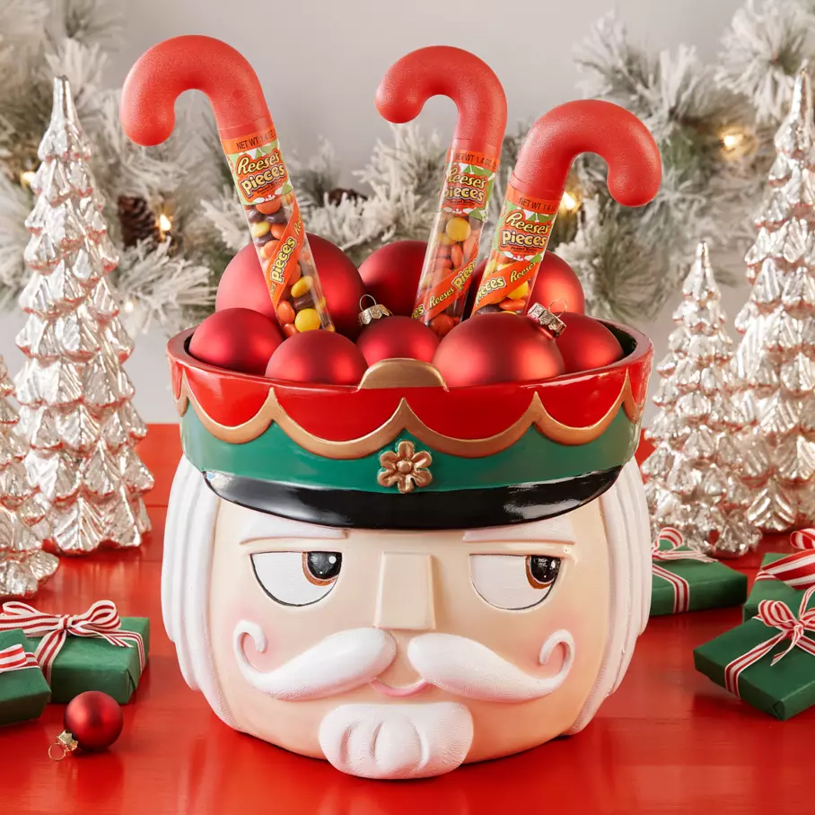 nutcracker themed bowl filled with ornaments and reeses pieces holiday peanut butter candy canes