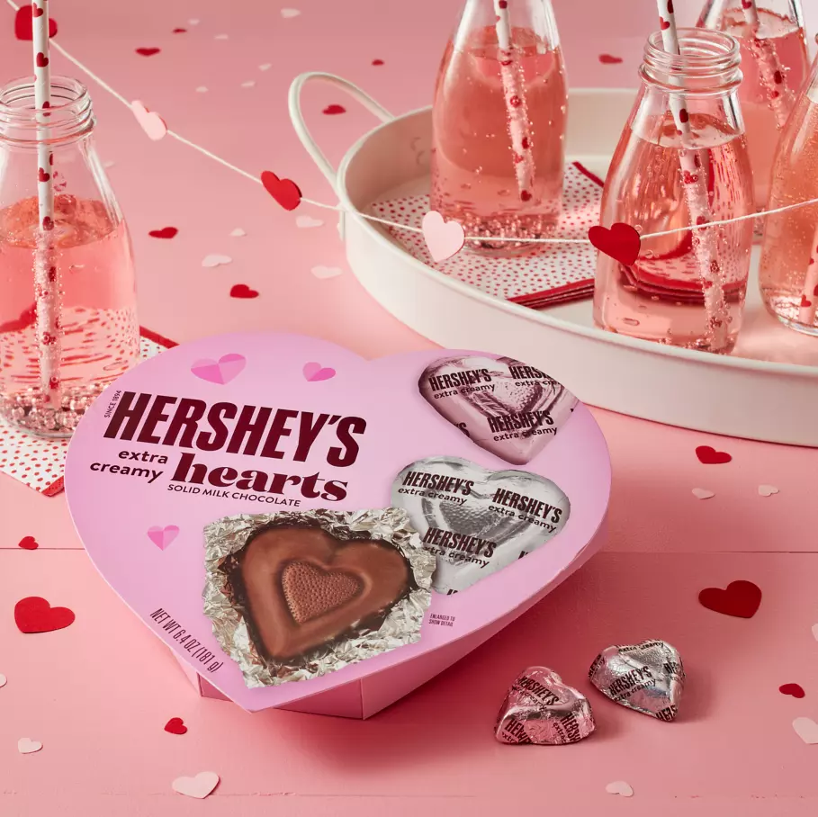Box of HERSHEY'S Milk Chocolate Hearts on decorated table with paper hearts