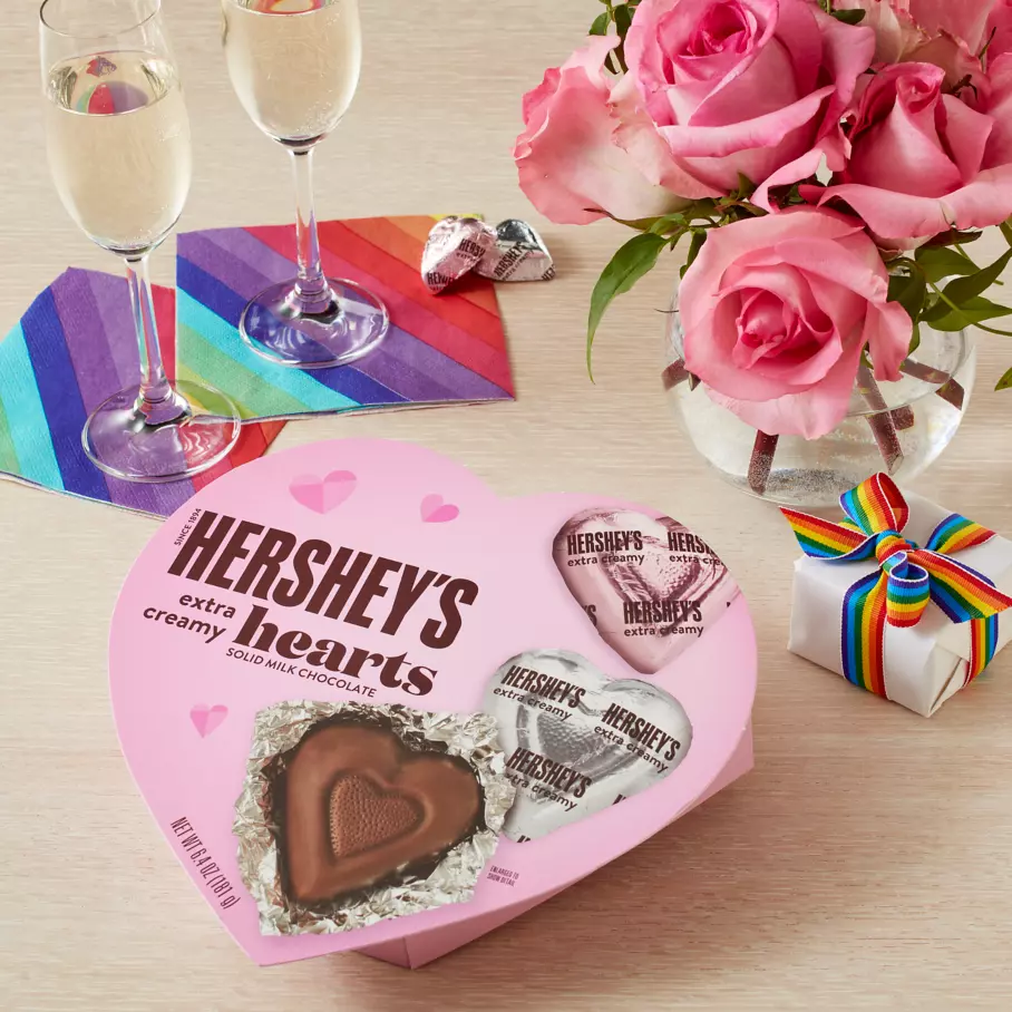 hersheys extra creamy milk chocolate hearts box beside bouquet of flowers and gifts