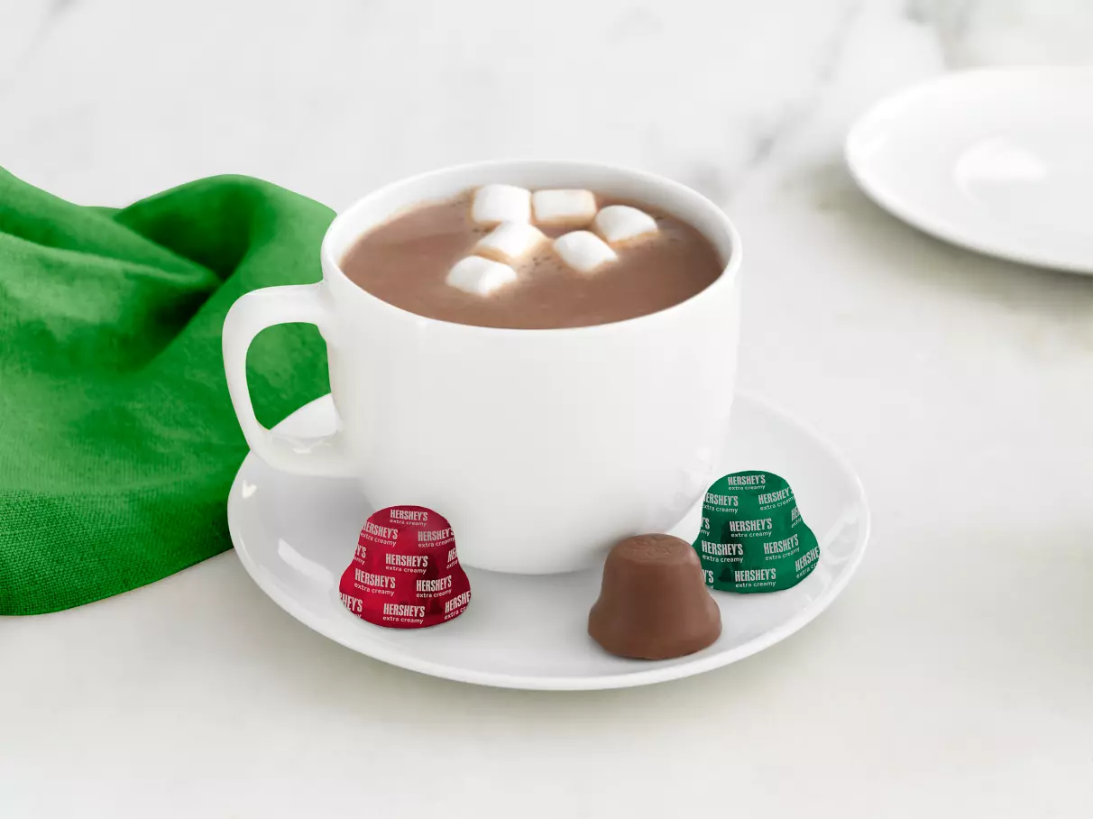 HERSHEY'S Milk Chocolate Holiday Bells with a mug of hot cocoa