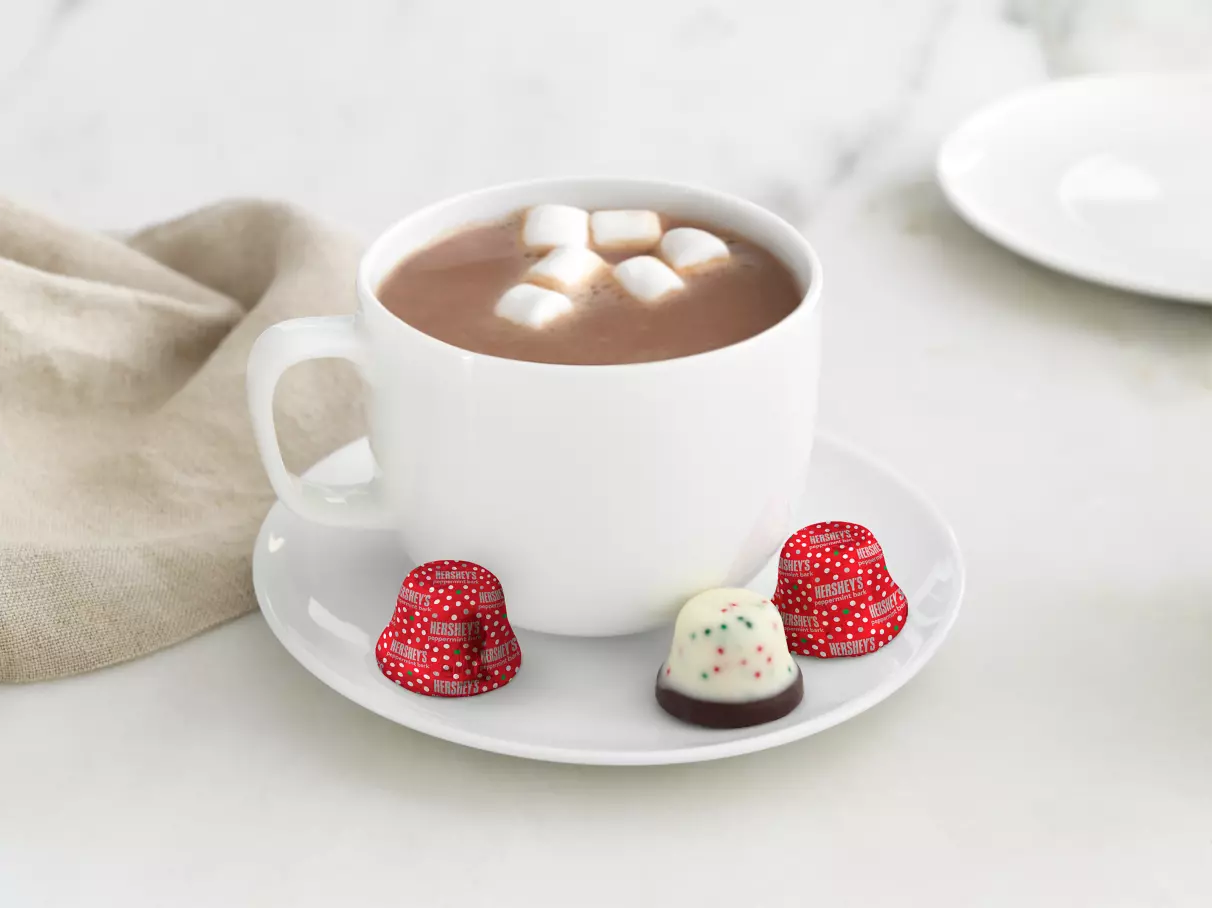 HERSHEY'S Peppermint Bark Bells with a mug of hot cocoa