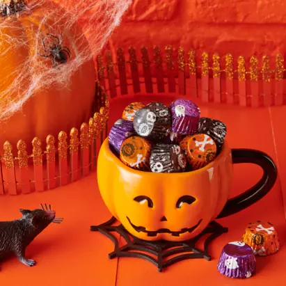 https://s7d1.scene7.com/is/image/hersheyprodcloud/20210615_Halloween_Reeses_PBC_Miniature_HalloweenFoils_FINAL_0781?fmt=webp-alpha&hei=411&qlt=75