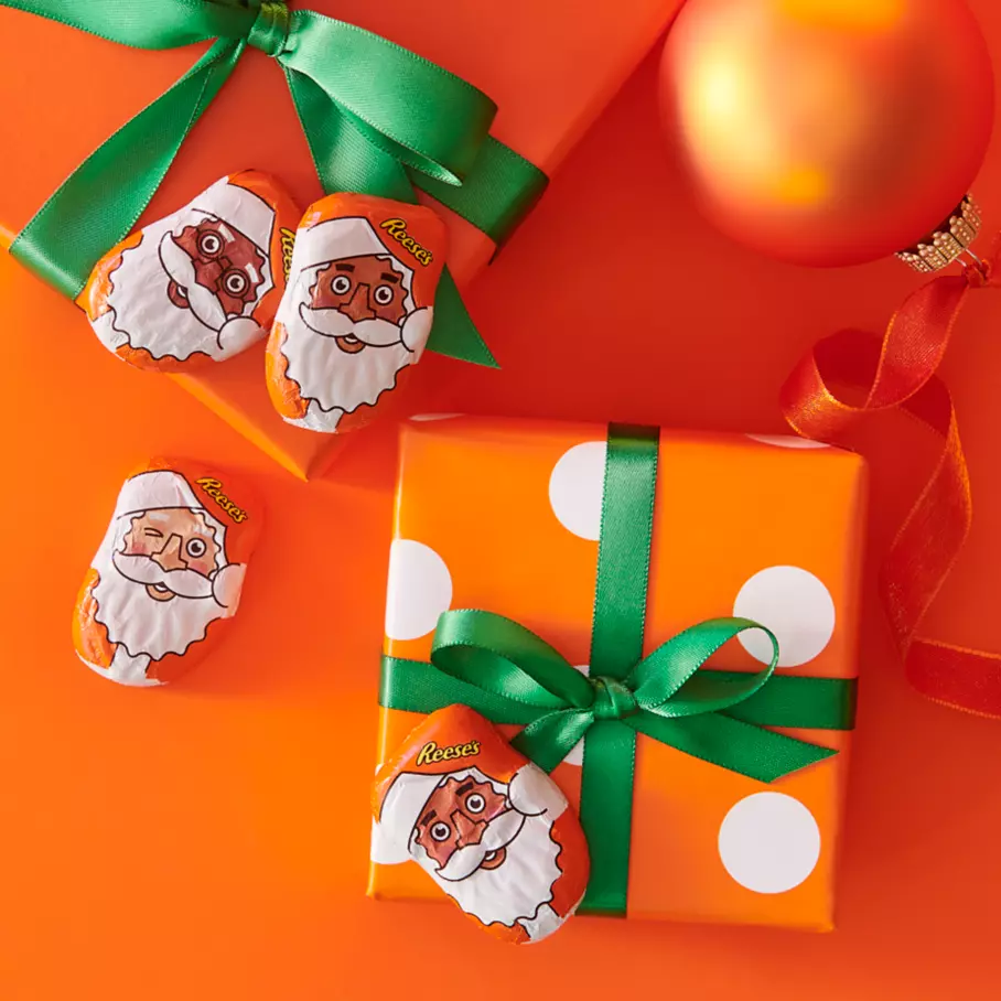 REESE'S Milk Chocolate Peanut Butter Santas beside Christmas presents