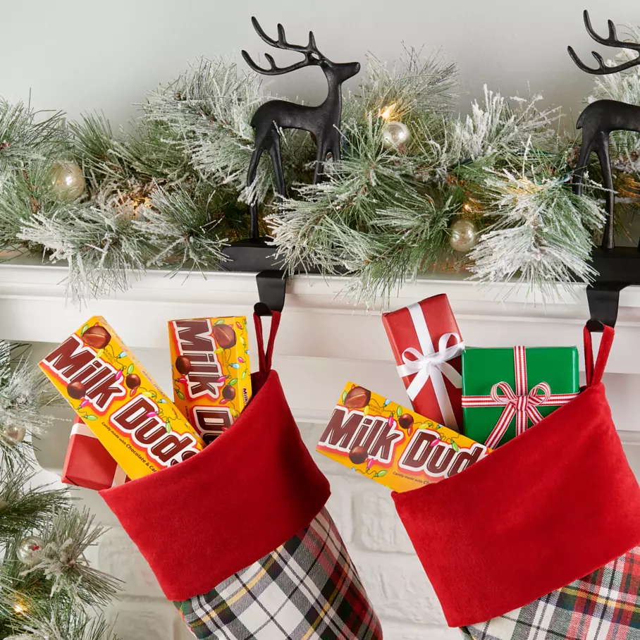 Boxes of MILK DUDS Holiday Candy inside Christmas stockings