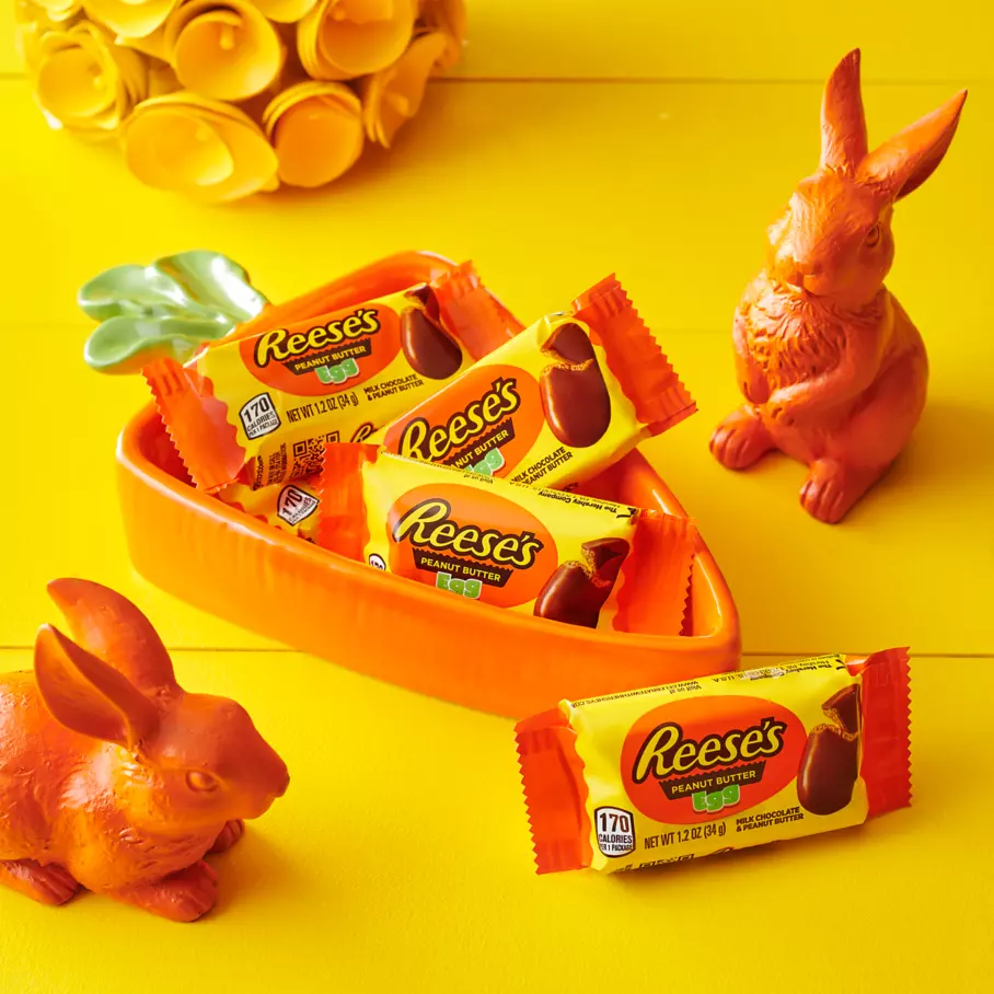 carrot shaped bowl filled with packs of reeses milk chocolate peanut butter cups