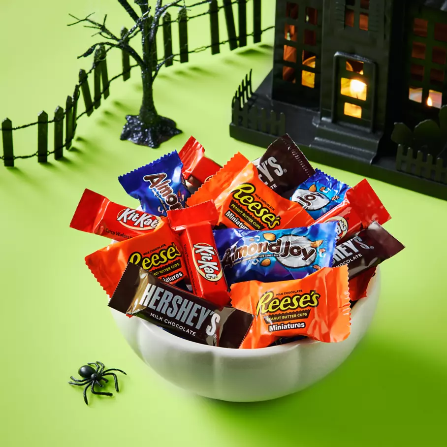 White pumpkin bowl full of assorted hersheys snack size candy