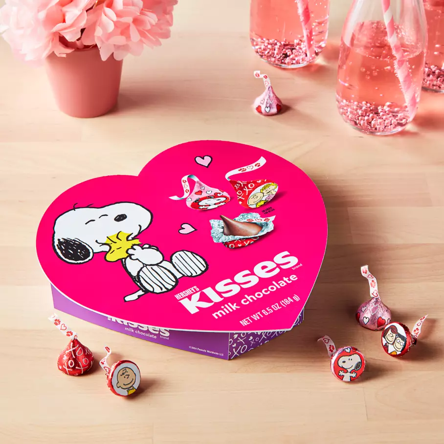 hersheys kisses snoopy and friends gift box beside bouquet of flowers and beverages