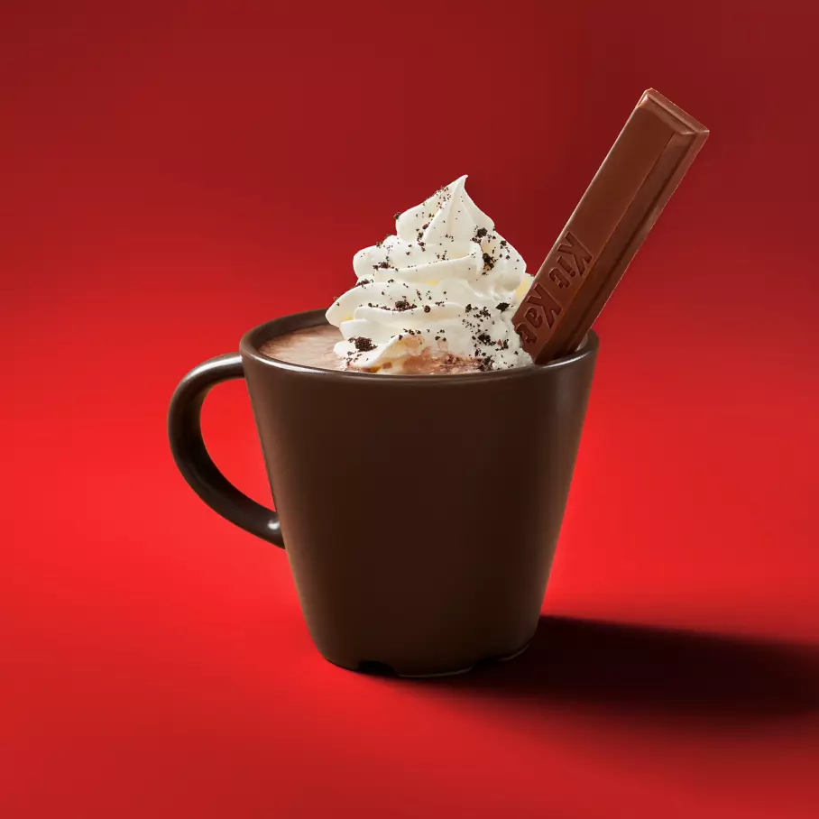 mug of hot cocoa topped with whipped cream and kit kat milk chocolate snack size wafer