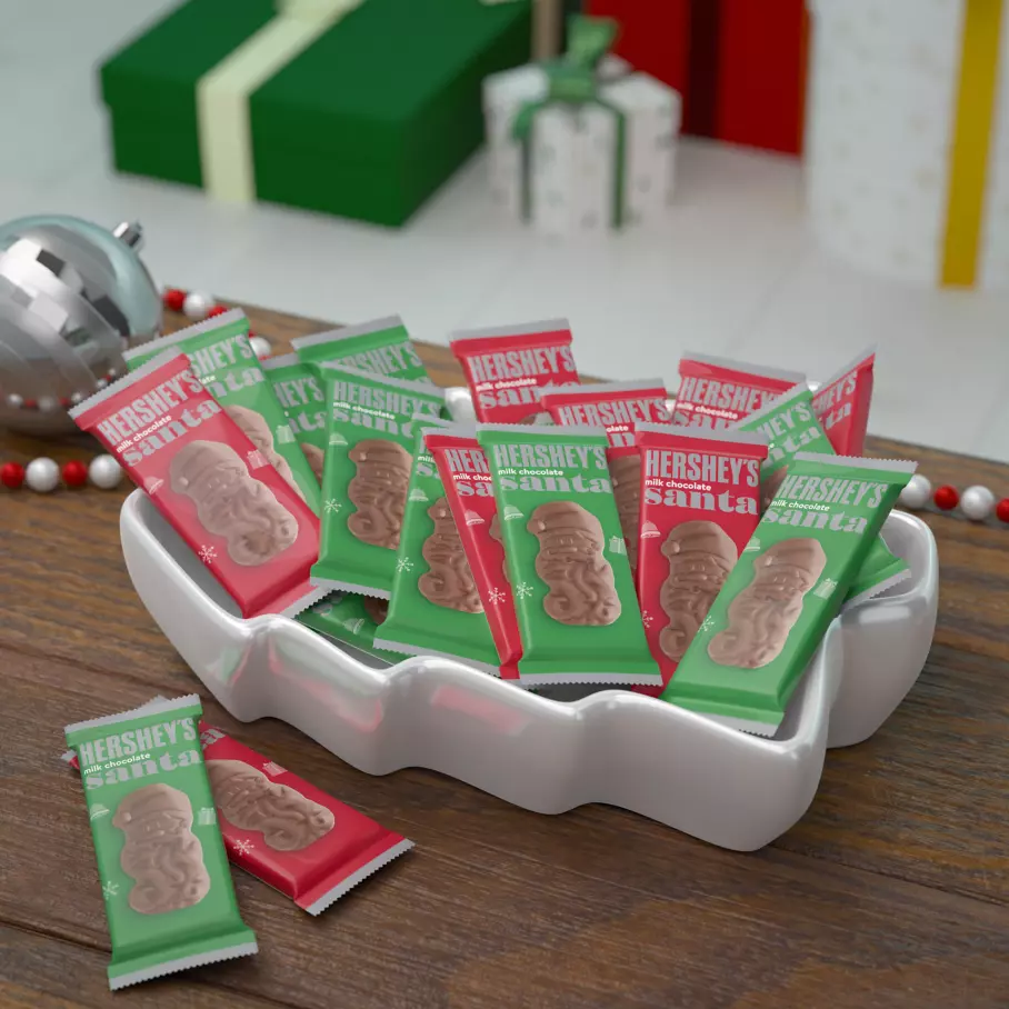 white tree bowl filled with red and green packs of hersheys milk chocolate santas