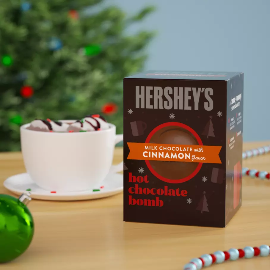HERSHEY'S Milk Chocolate Bomb beside mug of hot cocoa
