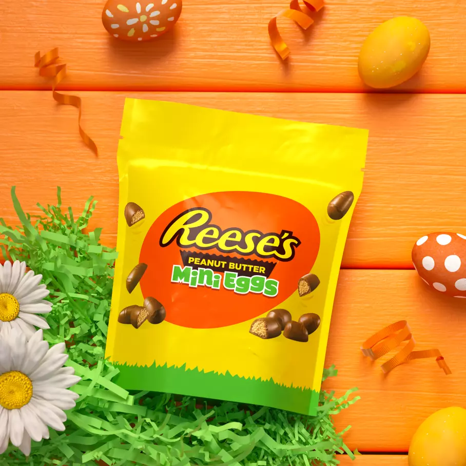 bag of reeses milk chocolate peanut butter mini eggs beside flowers and decorated eggs