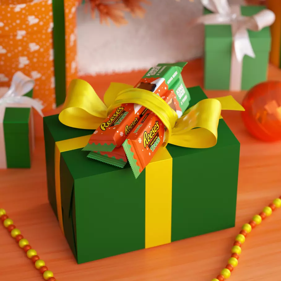 wrapped gift topped with packs of reeses milk chocolate peanut butter king size trees