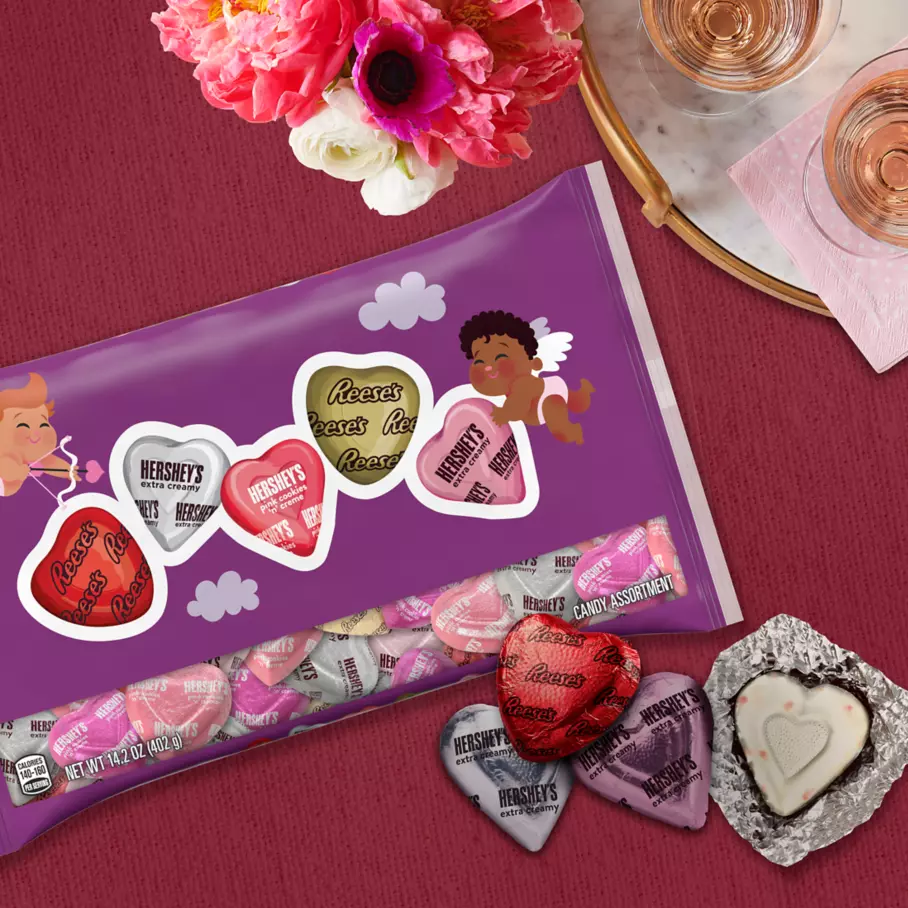 bag of assorted hersheys hearts candy beside bouquet of flowers and tray of drinks