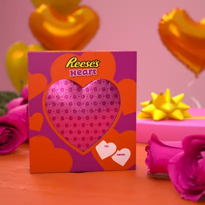 https://s7d1.scene7.com/is/image/hersheyprodcloud/Vday_Reeses_Giant_Heart_In_A_Box_eComm_V2?fmt=webp-alpha&hei=411&qlt=75