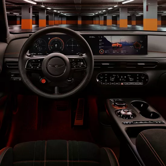 Interior driver seat pov of steering wheel, OLED display & center console inside Genesis GV60 Magma