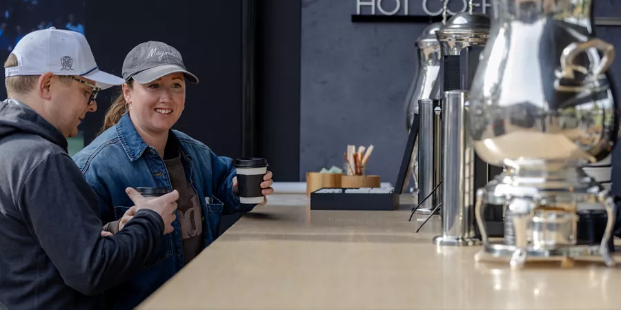Attendees drinking coffee in the guest lounge at the 2026 Genesis Invitational