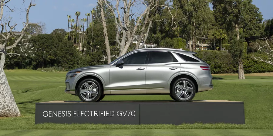 Side profile of silver Genesis Electrified GV70 on display platform at 2026 Genesis Invitational