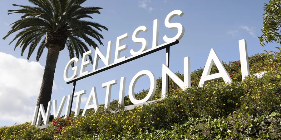 "Genesis Invitational" sign against lush green hillside & palm trees at 2026 Genesis Invitational