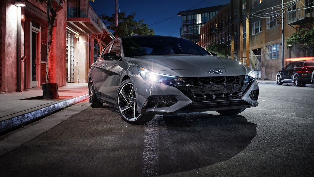 2023 Hyundai Elantra parked on road at night with headlights shining