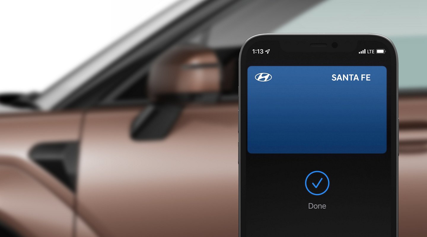 Smartphone showing a Hyundai Santa Fe digital key next to the vehicle