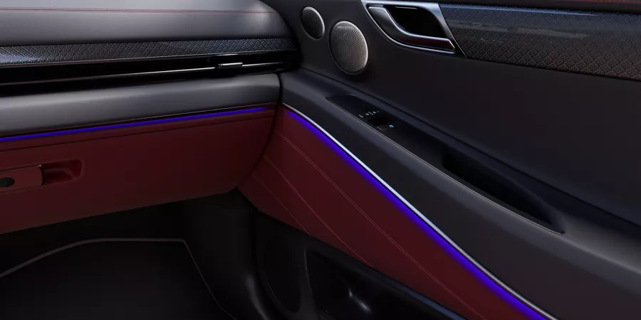 Interior passenger side close up of Genesis GV80 Coupe AWD in Sevilla Red with ambient lighting