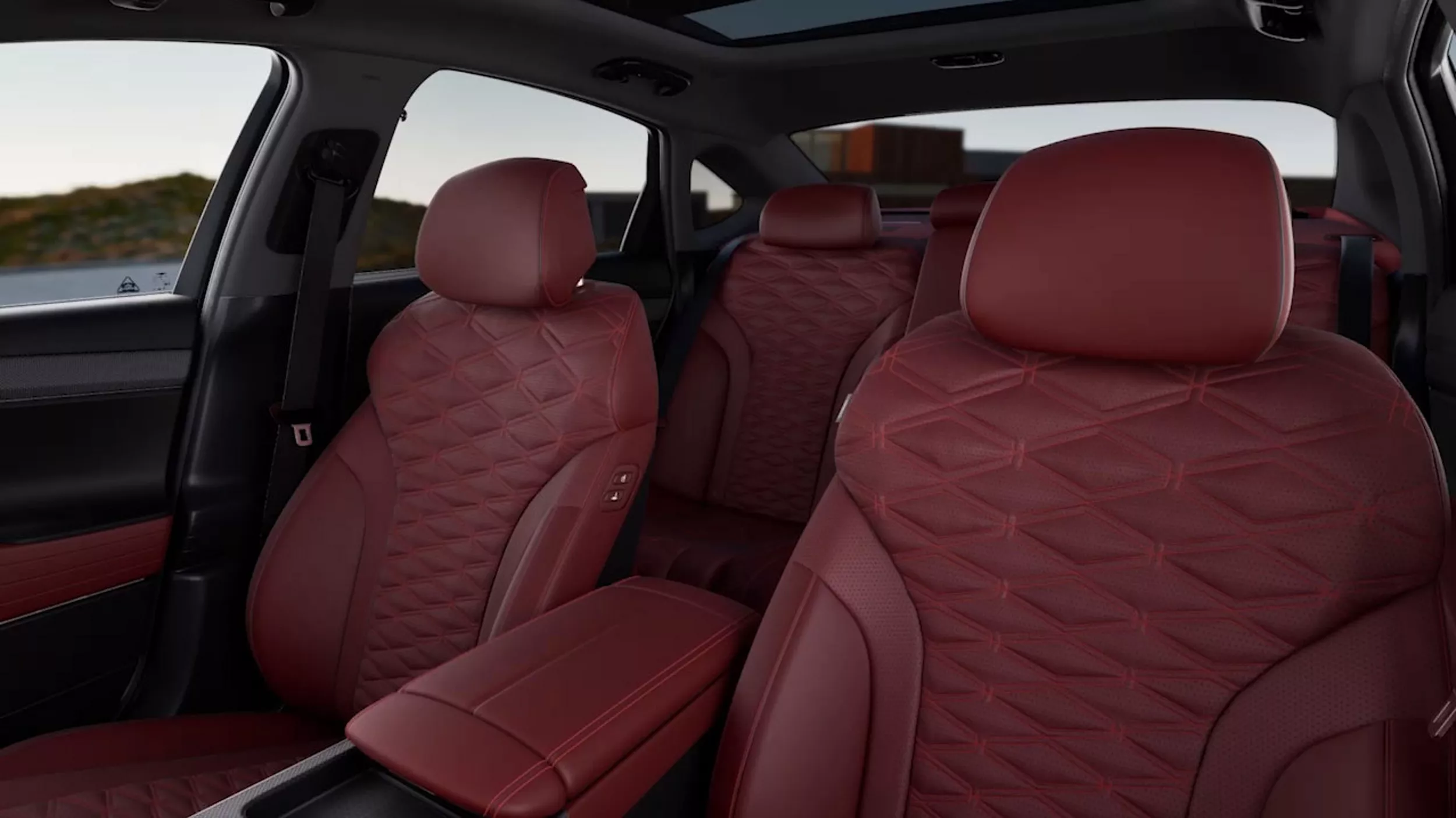Genesis G80 rear cabin view from front driver seat, showing red nappa leather seats and sunroof