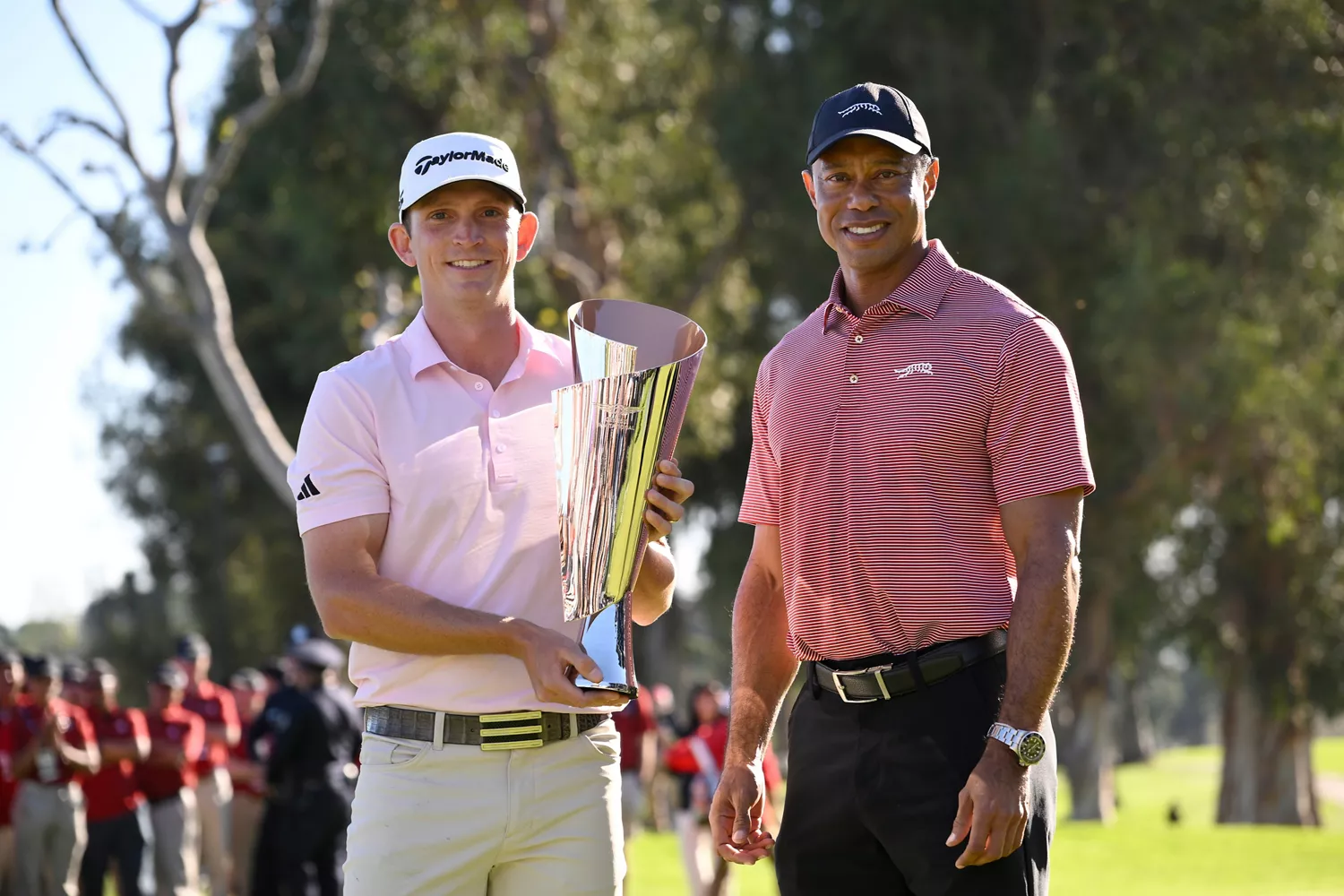 Jacob Bridgeman holds 2026 Genesis Invitational trophy, next to Tiger Woods at Riviera Country Club
