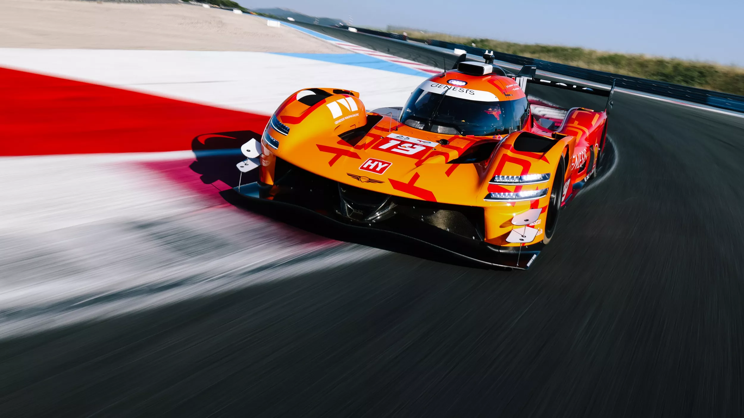 3/4 front driver side view of Genesis Magma Racing GMR-001 Hypercar in Magma Orange on racetrack