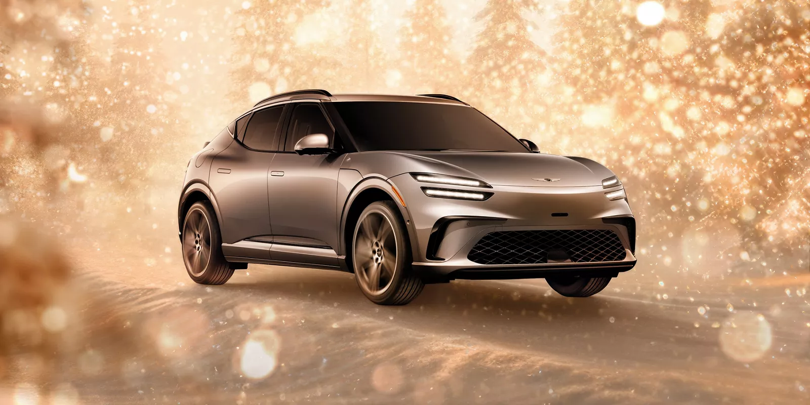 3/4 front passenger side view of gray 2026 Genesis GV60 parked in snowy, gold sparkling environment