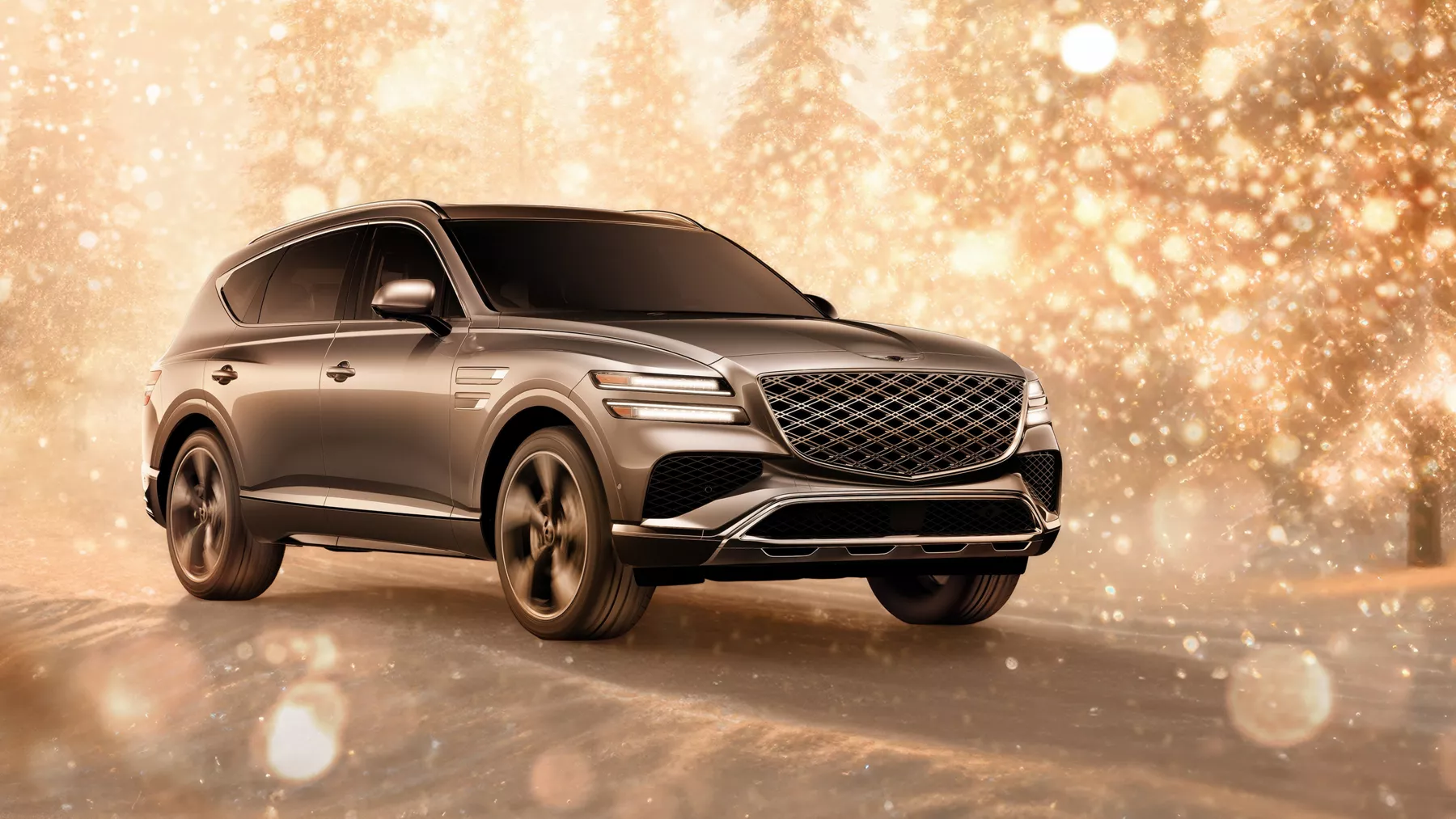 3/4 front passenger side view of gray 2026 Genesis GV80 parked in snowy, gold sparkling environment