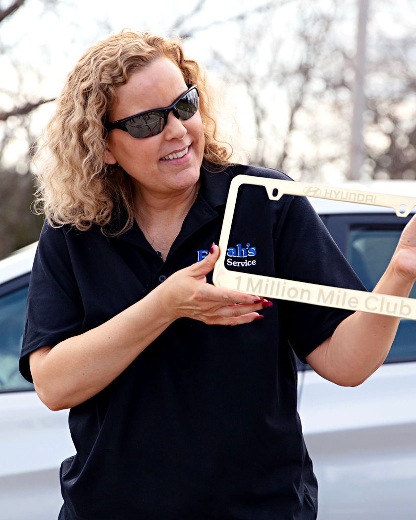 Farrah Haines holds up her Million Mile Club license plate frame