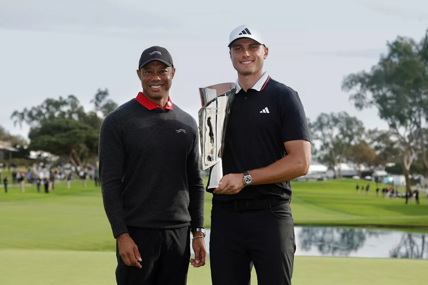 2025 Genesis Invitational winner Ludvig Åberg holding trophy, standing next to Tiger Woods