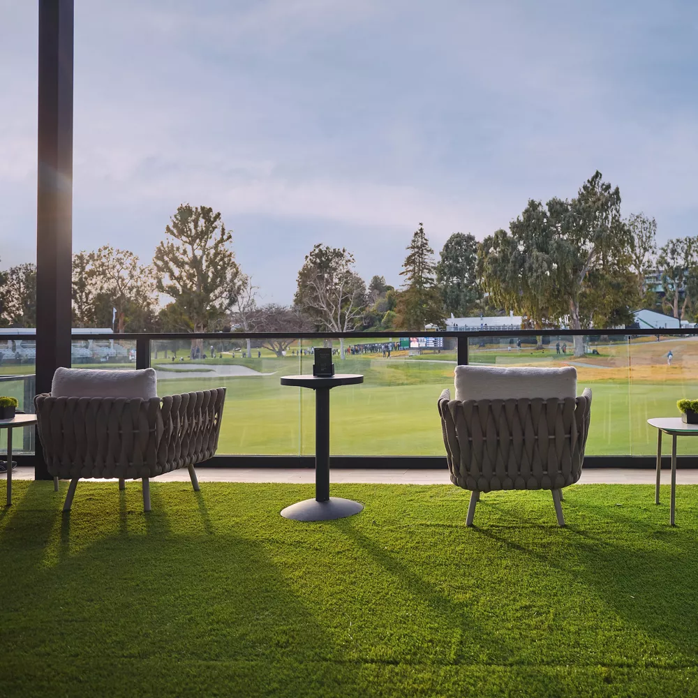 Photo of chairs overlooking grass within a lounge area at the Genesis Invitational