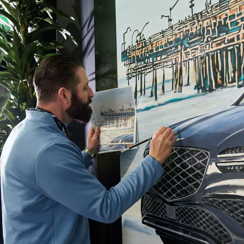 Artist Jonas Never painting a mural in the Genesis Invitational Lounge