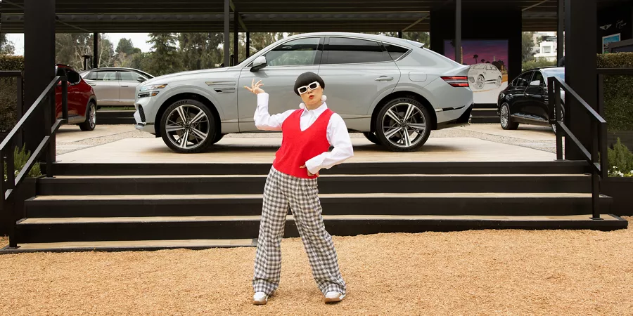 Celebrity influencer standing in front of Genesis vehicle