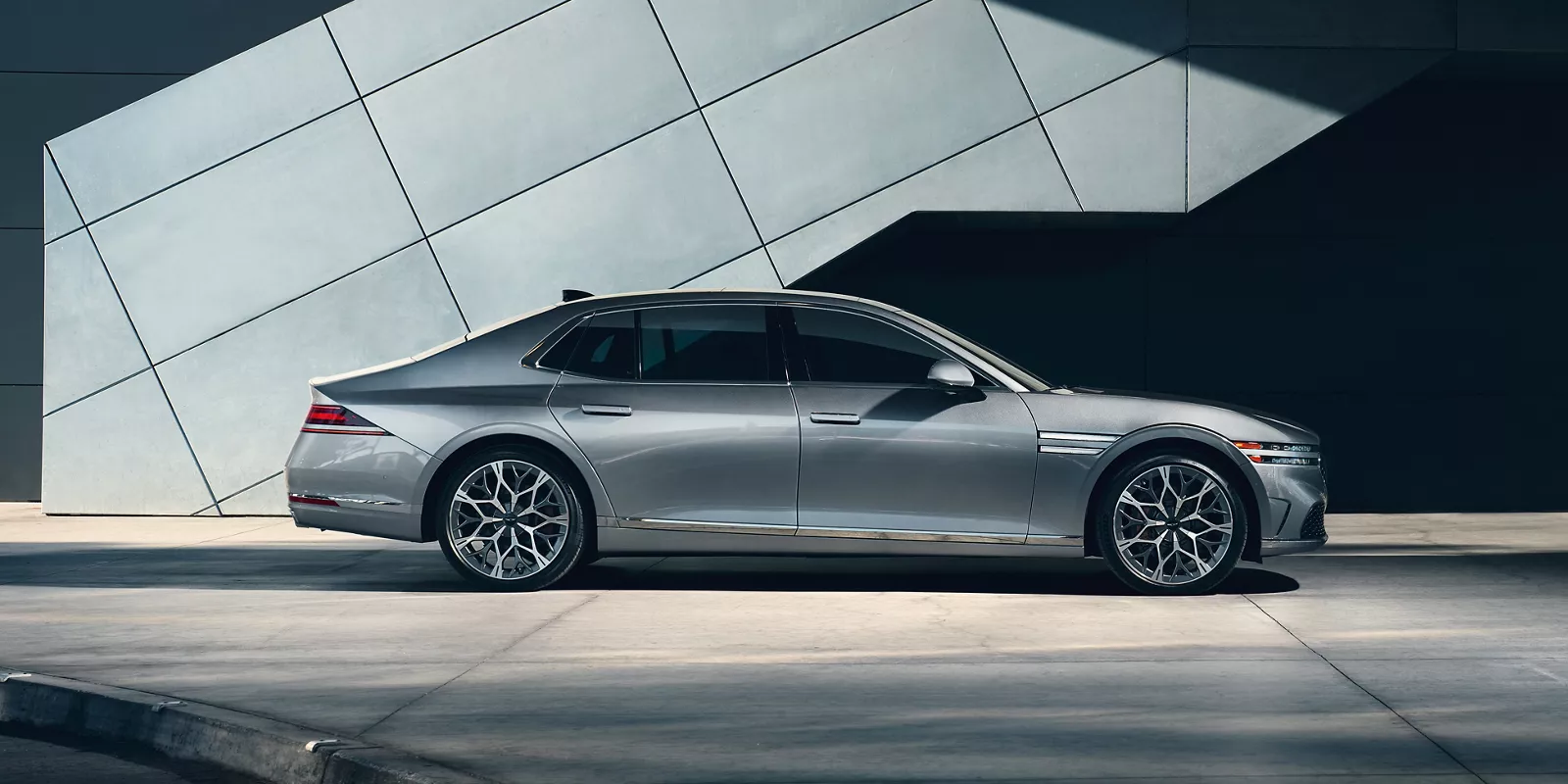 Genesis G90 side view with glass building background