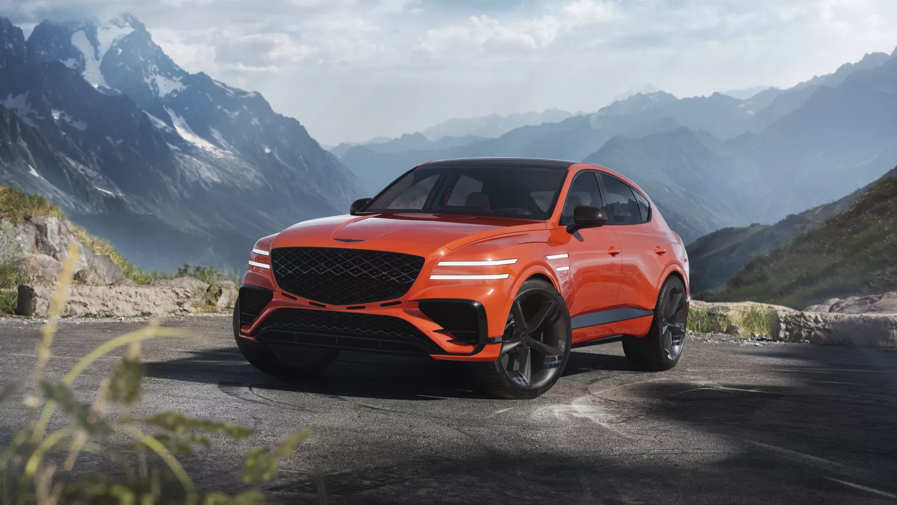GV80 Coupe Concept is dramatically positioned against a mountain landscape.