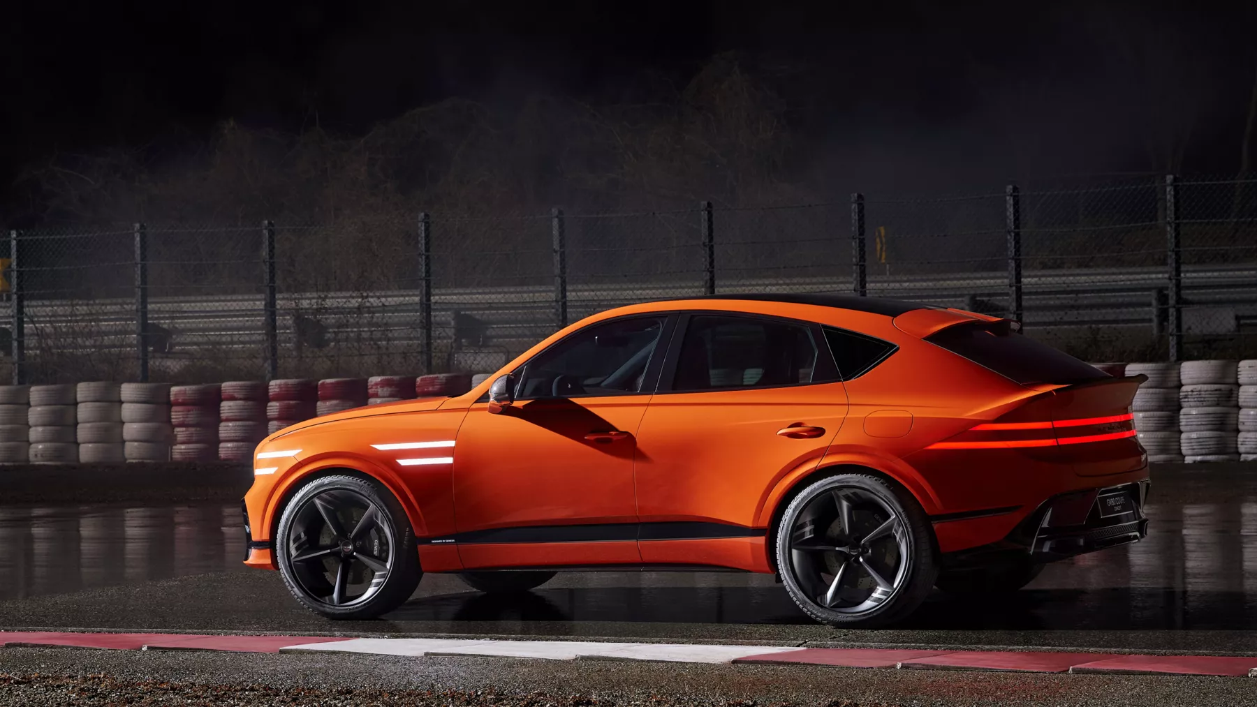 Side profile of the GV80 Coupe Concept on a racetrack.