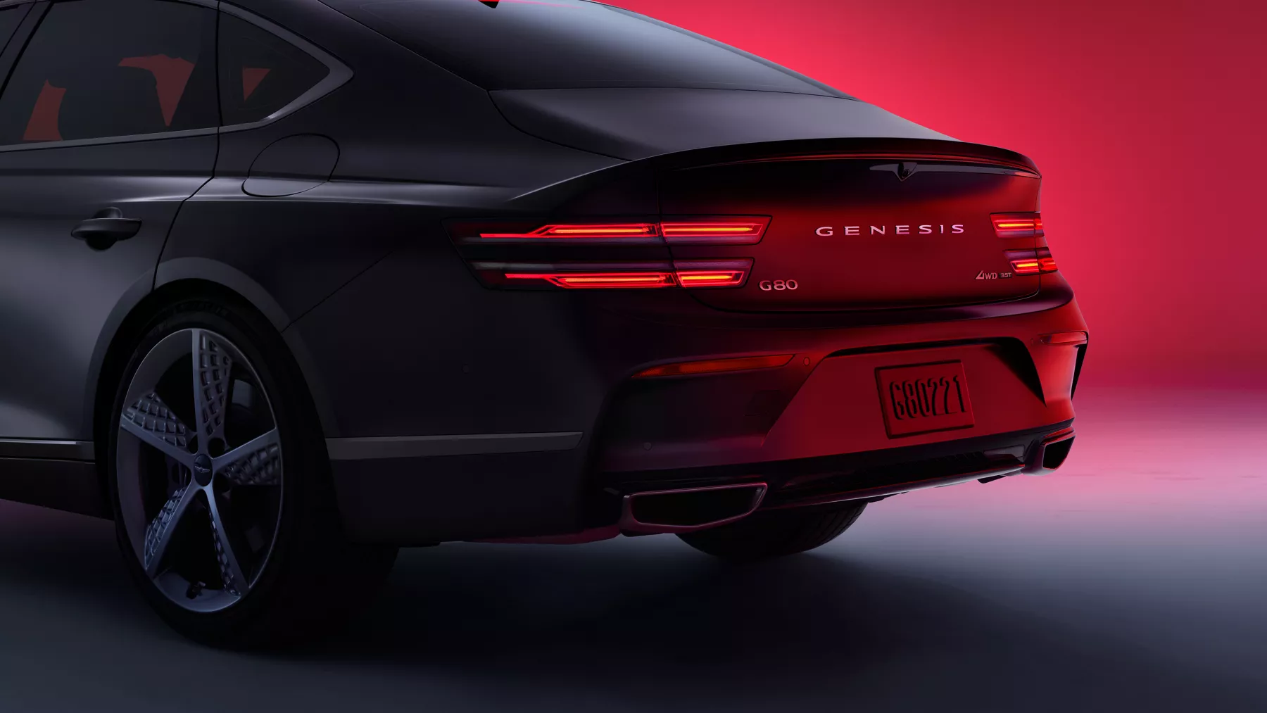 G80 rear tail lights and trunk parked in front of a red background.